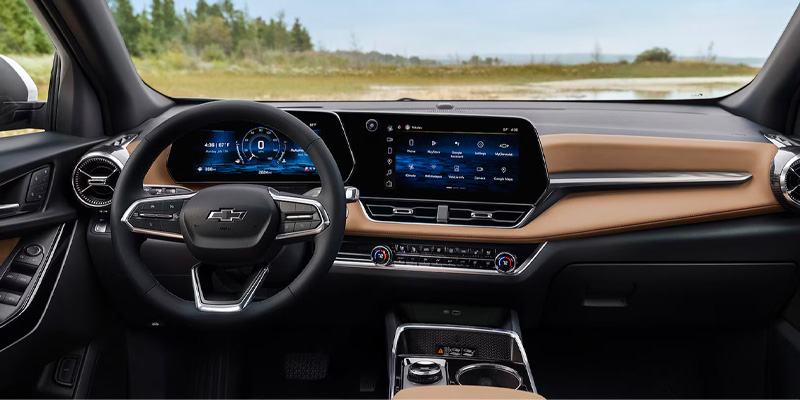 A view of the modern, sleek interior of a Chevrolet vehicle, featuring a large digital dashboard, infotainment system, and leather-trimmed steering wheel