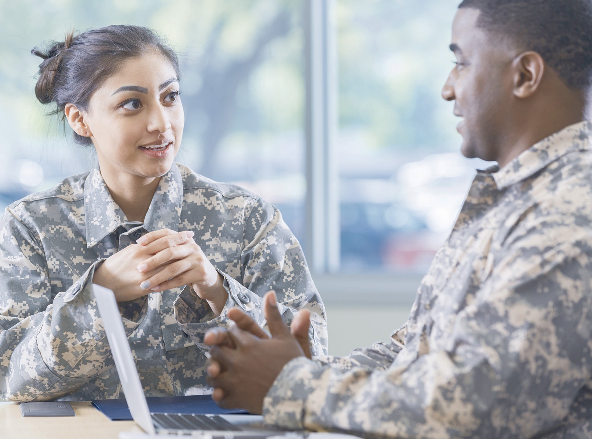 Two soldiers talking over a laptop